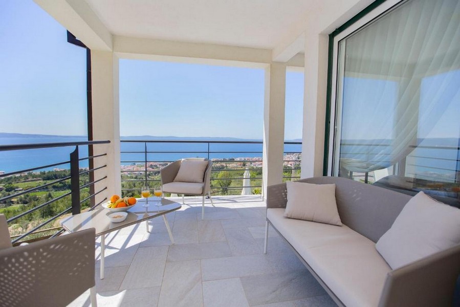 Balcone coperto con divano e vista sul paese fino al mare