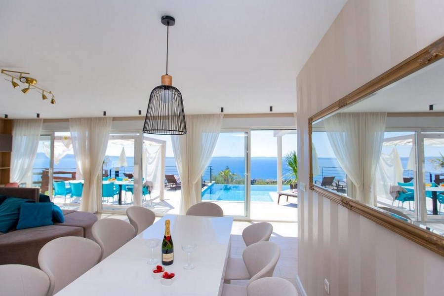 Tavolo da pranzo davanti alla vetrata con la piscina dietro