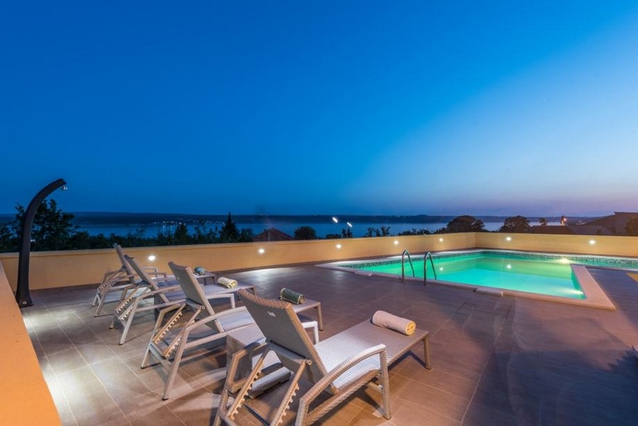 Piscina illuminata con lettini all'ora blu