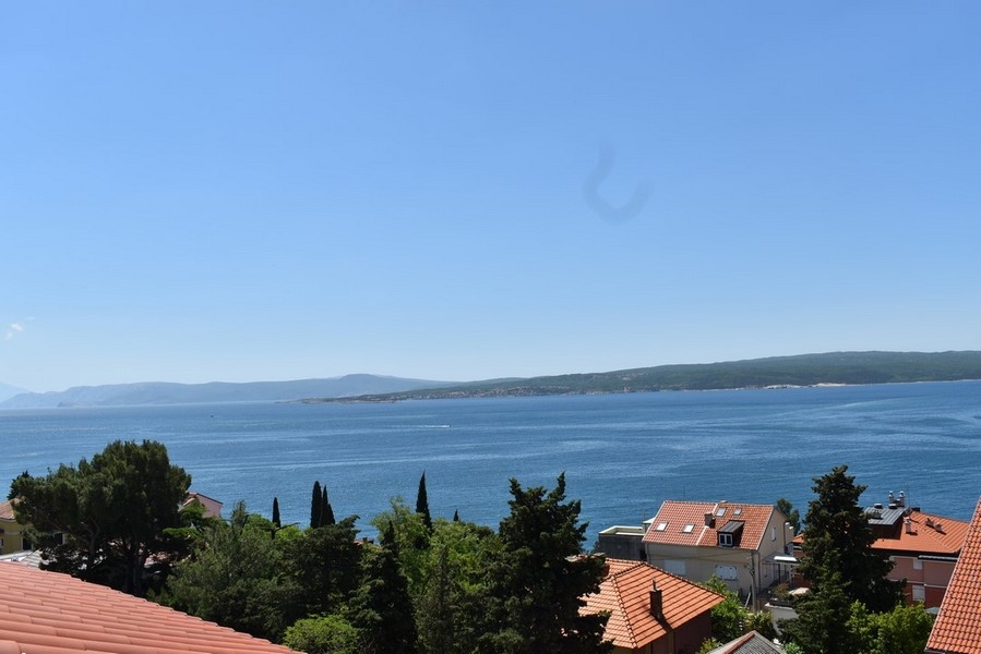 Vista sui tetti di tegole e sui cipressi fino alla baia