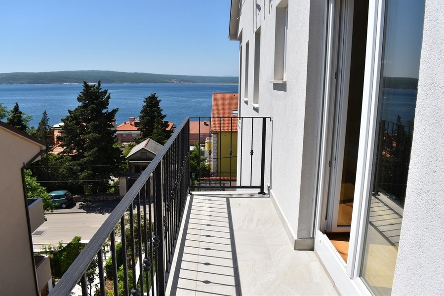 Balcone stretto con vista sui cipressi e sulla baia
