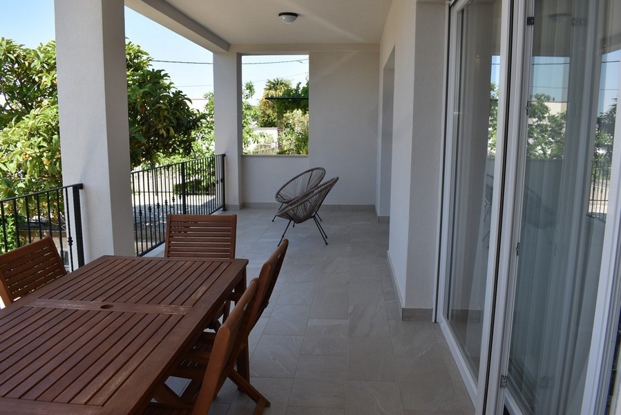 Terrazza coperta con tavolo da pranzo e poltrona rotonda