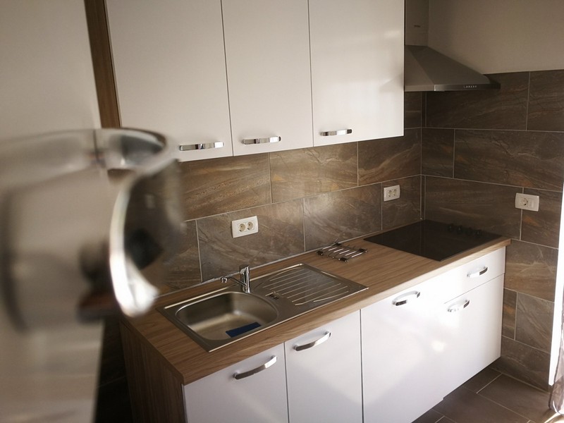 Cucina lineare con piano in legno e cappa