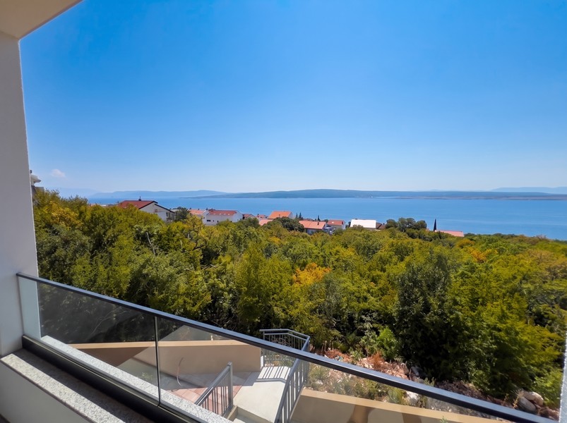 Balcone con parapetto in vetro e vista sulla macchia mediterranea fino al mare