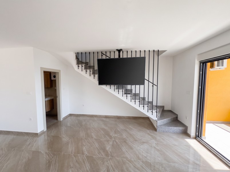Soggiorno con scala per il piano superiore e accesso al bagno - H2197