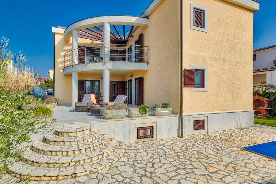 Villa con balcone rotondo e scala curva in pietra naturale