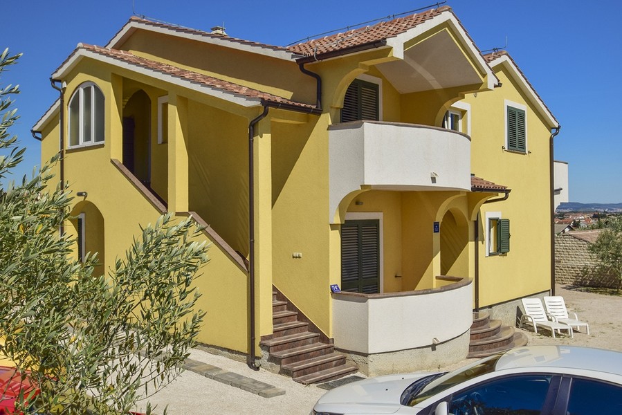 Casa gialla con balcone rotondo e scala esterna