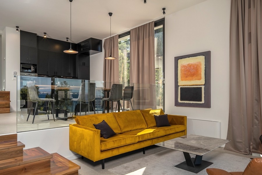 Divano giallo con vista sulla cucina e sulla zona pranzo