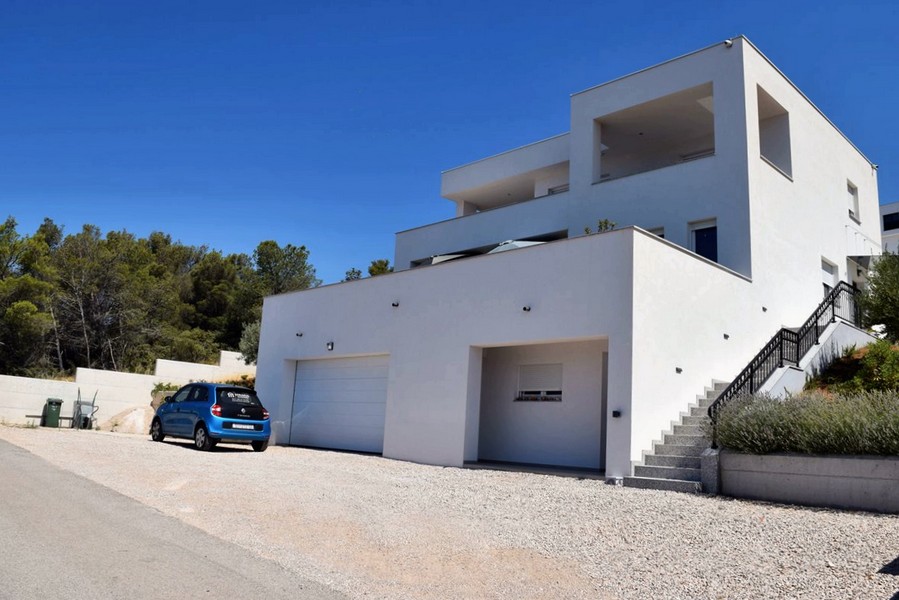 Villa bianca con garage e scala esterna sul pendio