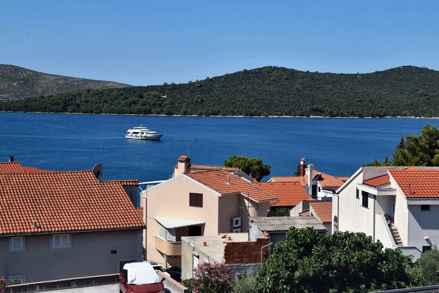 Vista sopra i tetti di tegole sulla baia con battello turistico