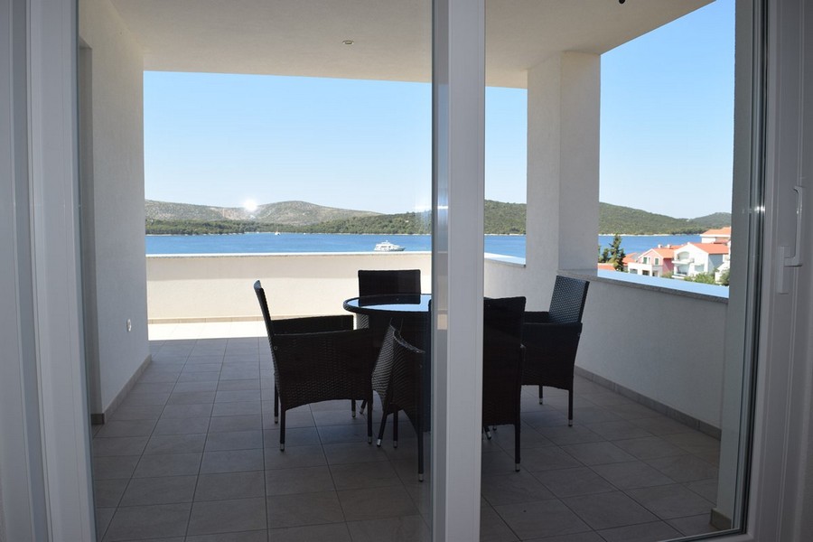 Vista attraverso la porta scorrevole sulla loggia con tavolo da pranzo