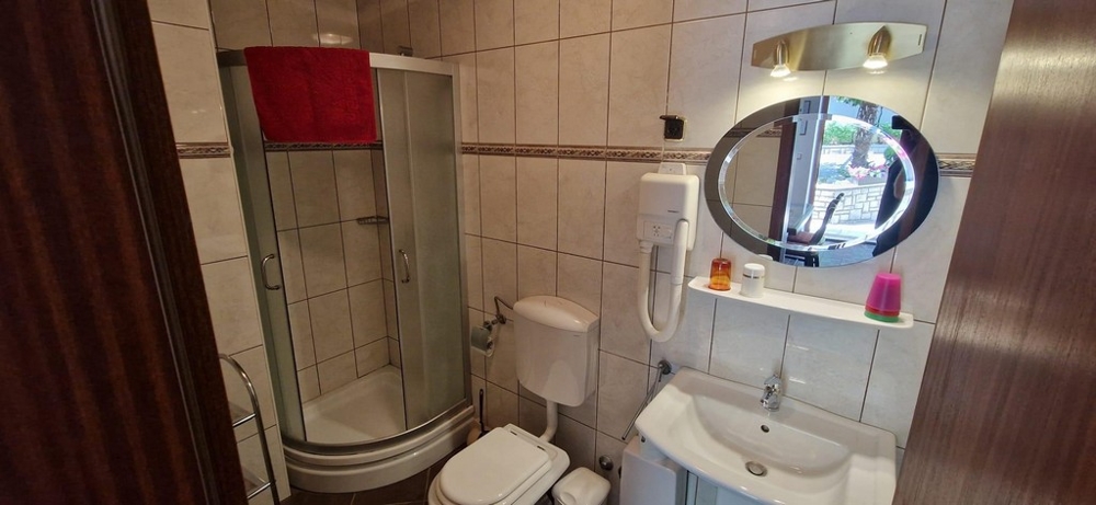 Bagno con box doccia rotondo e specchio ovale