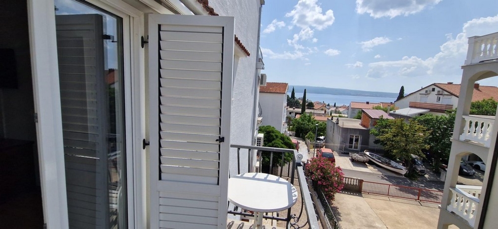 Balcone con persiane bianche e vista sul mare