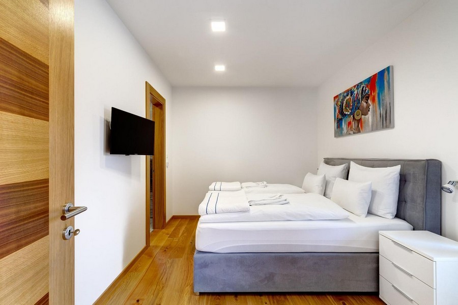 Camera da letto con letto imbottito grigio e quadro colorato