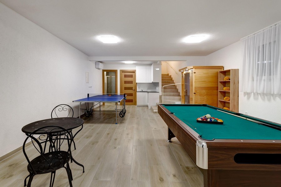 Sala giochi con tavolo da biliardo e tavolo da ping pong