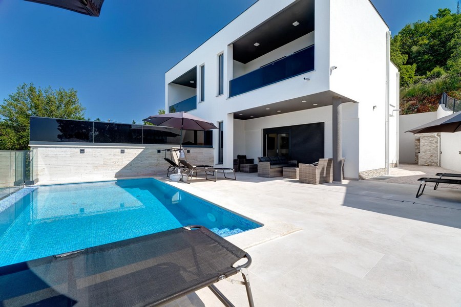 Piscina e lounge davanti alla casa bifamiliare con loggia