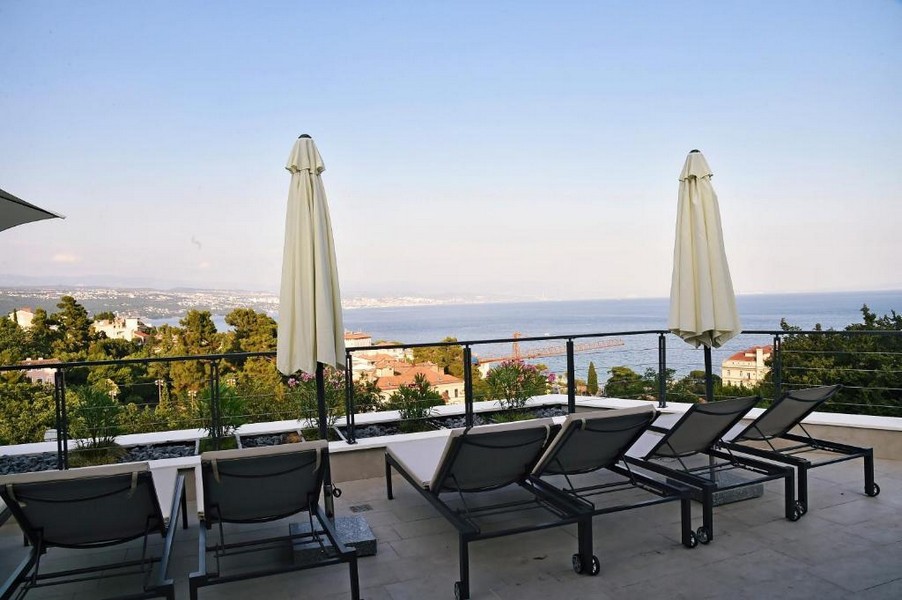 Grande terrazza sul tetto con lettini e vista panoramica sul mare