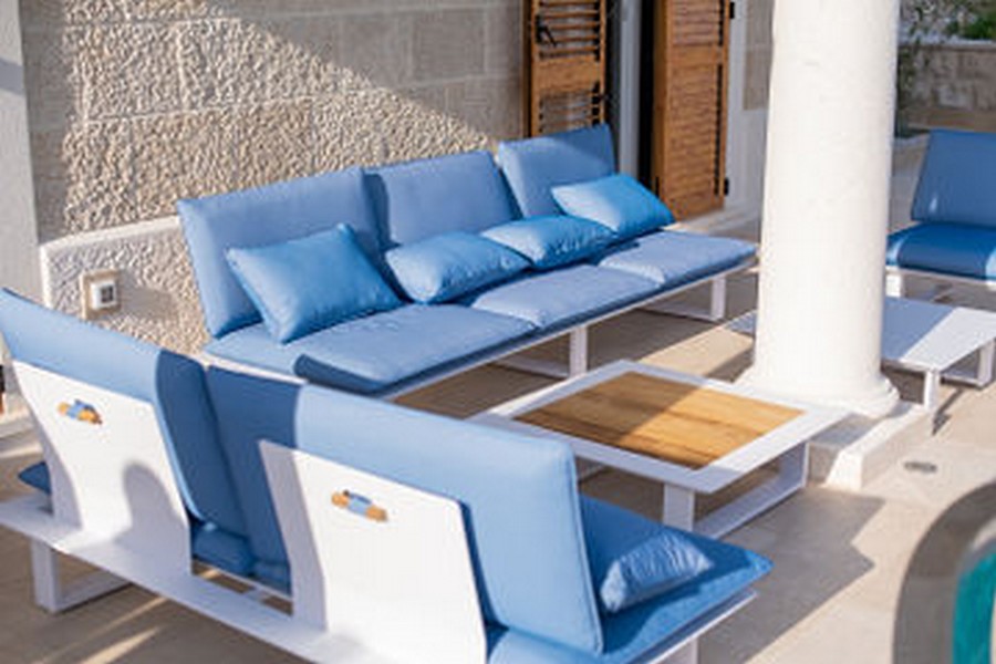 Gruppo lounge in blu davanti alla parete in pietra naturale