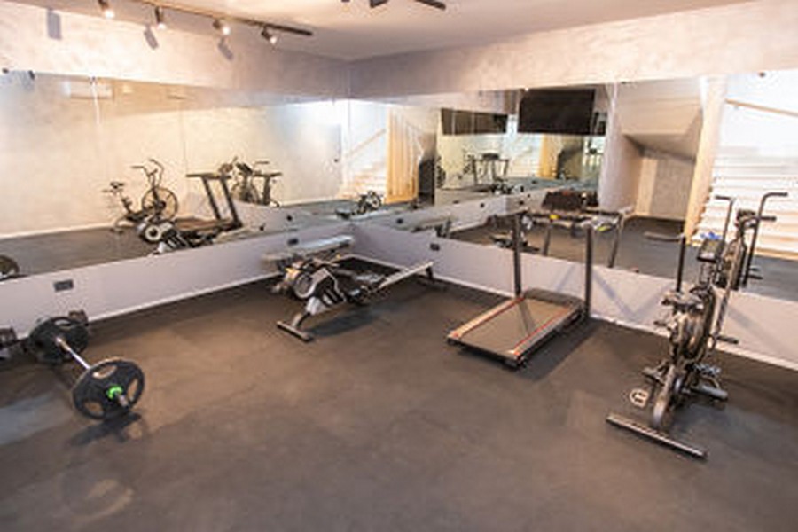 Palestra con tapis roulant, manubri e parete a specchio