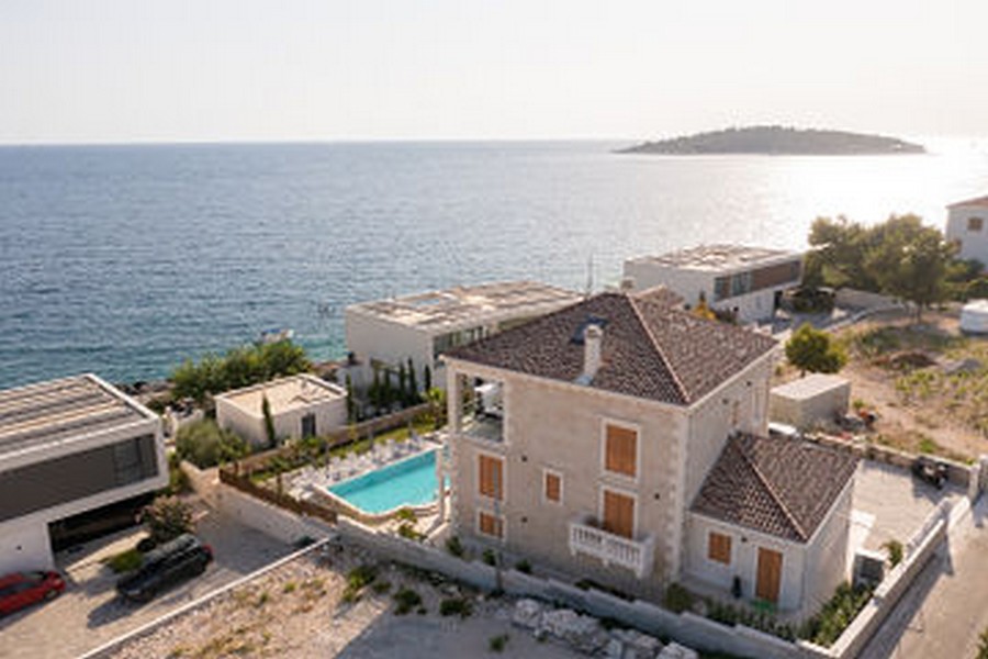 Veduta aerea della villa con piscina vicino alla riva del mare