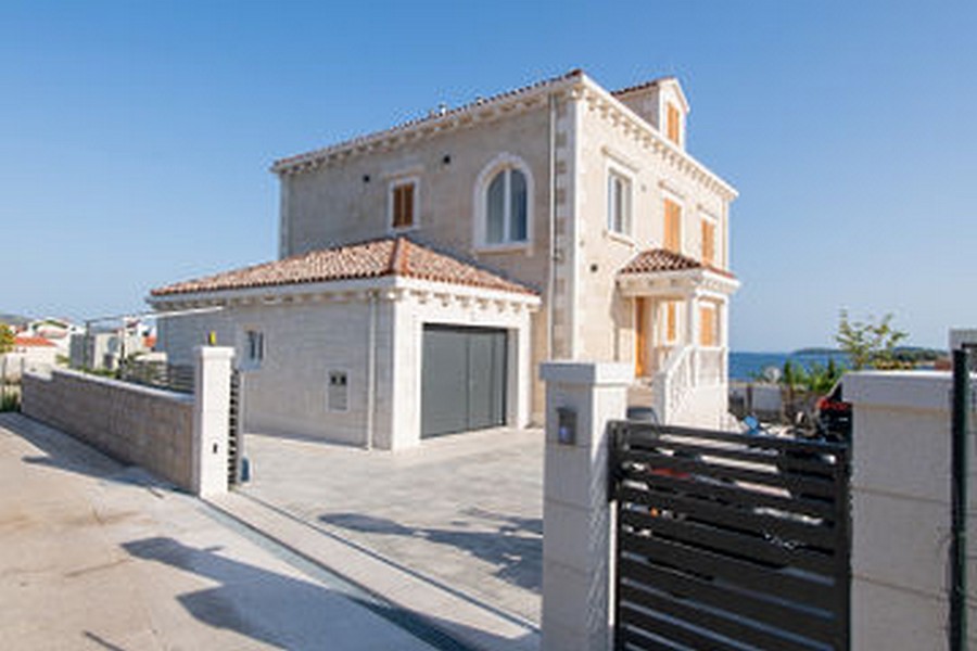 Fronte della casa con garage dietro la recinzione all'ingresso