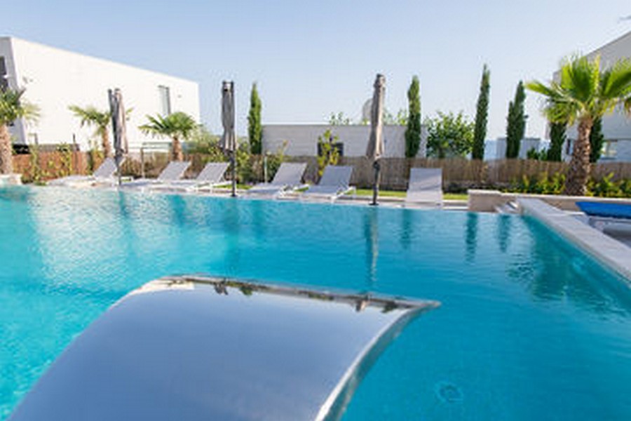 Piscina con scivolo e lettini sul bordo