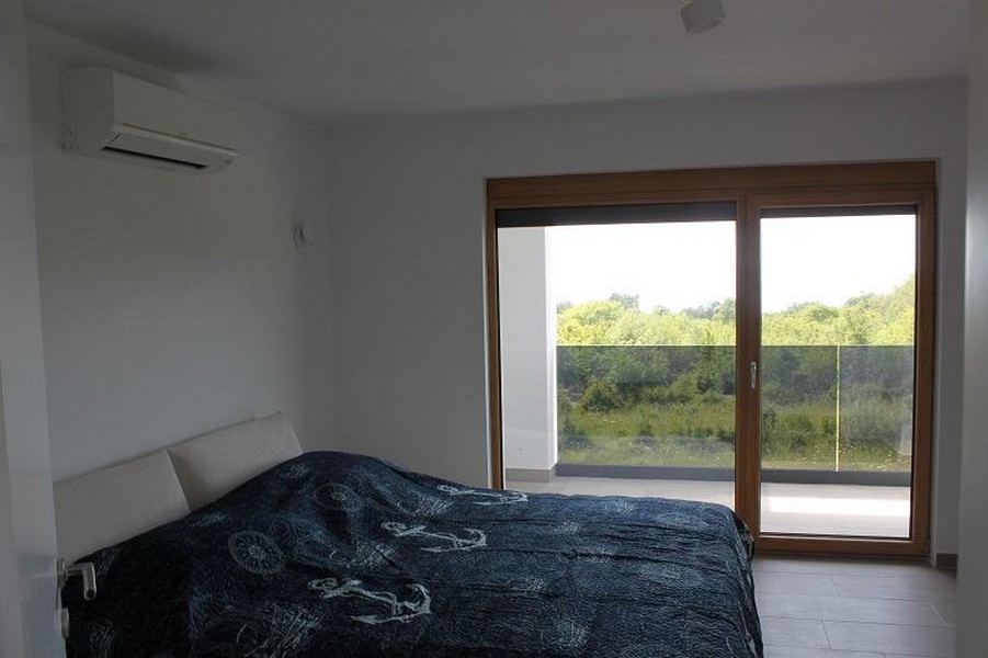 Camera da letto con porta scorrevole sul balcone nel verde
