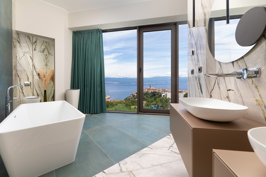 Bagno con vasca freestanding e finestra sulla costa
