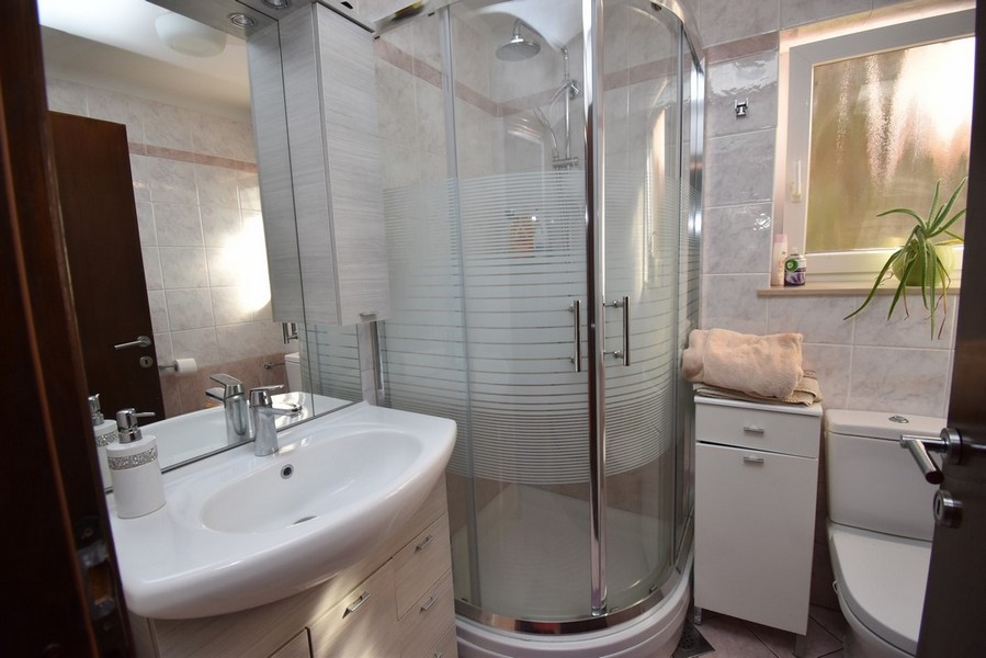Bagno con box doccia rotondo e lavabo