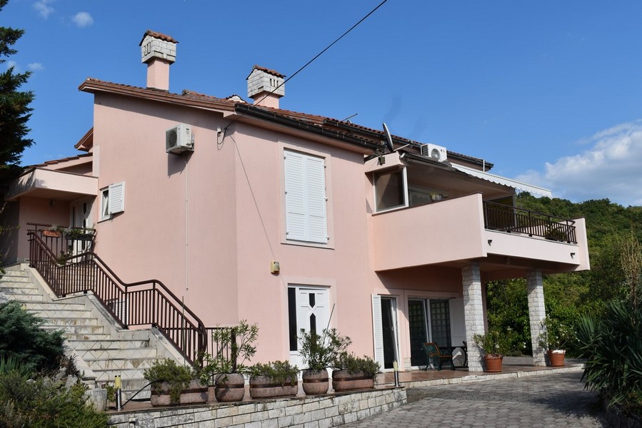 Casa rosa con scala esterna e balcone su colonne