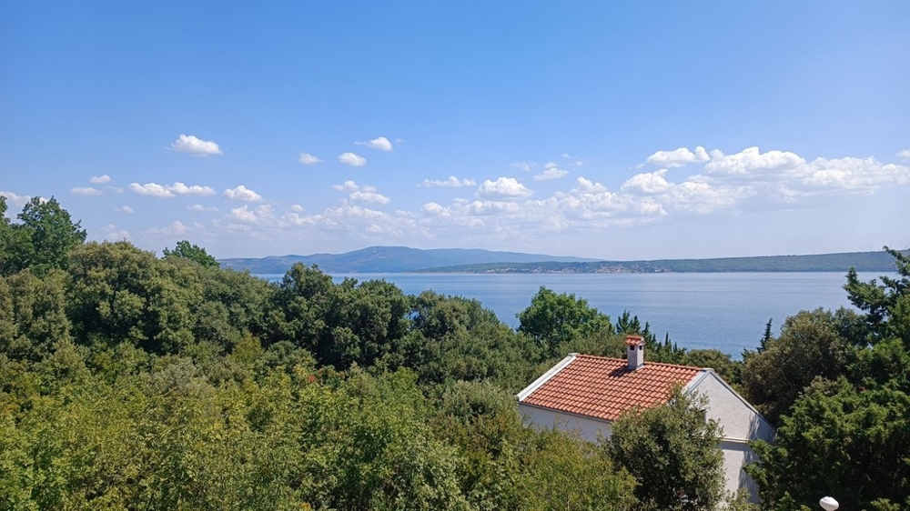 Vista mare sul paesaggio mediterraneo e casa con tetto di tegole rosse