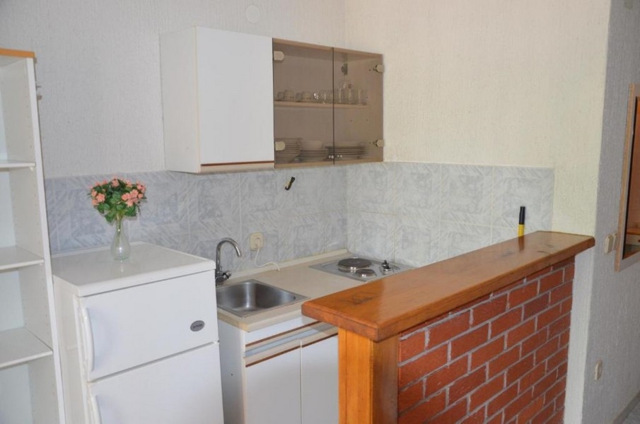 Piccola cucina lineare con bancone in legno e superfici chiare