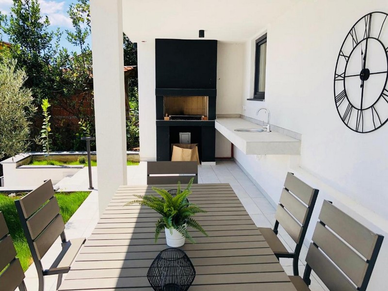 Terrazza coperta con camino e zona seduta