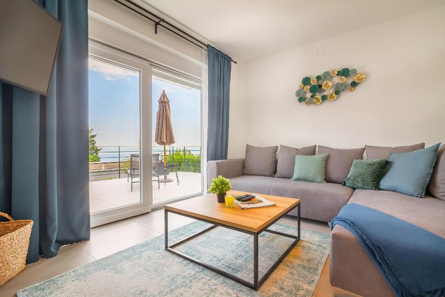 Soggiorno con divano e porta della terrazza