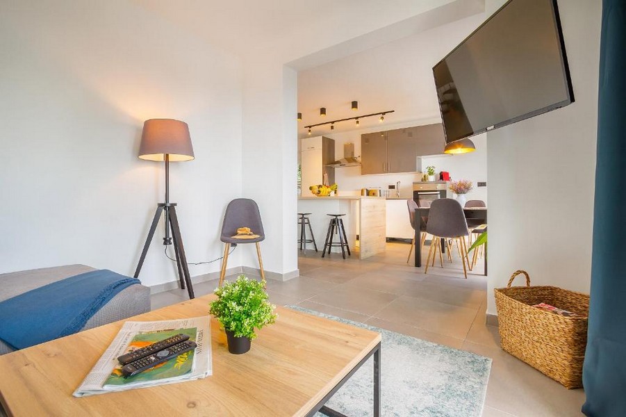 Zona giorno con lampada da terra e cucina aperta