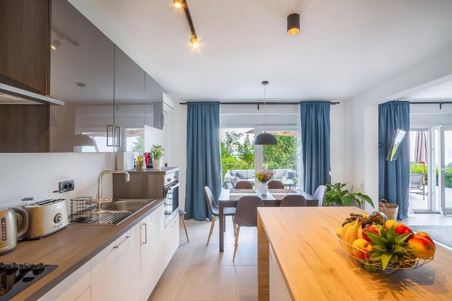 Cucina aperta con tavolo e porta della terrazza
