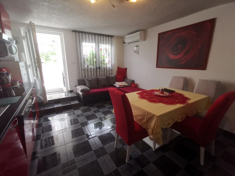 Cucina abitabile con divano rosso e tovaglia gialla