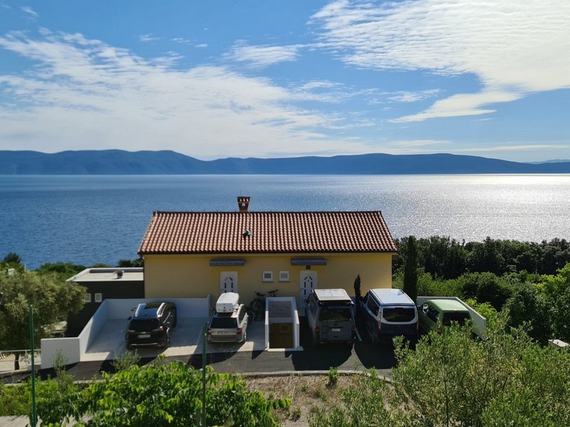 Vista esterna della casa con posti auto e vista mare