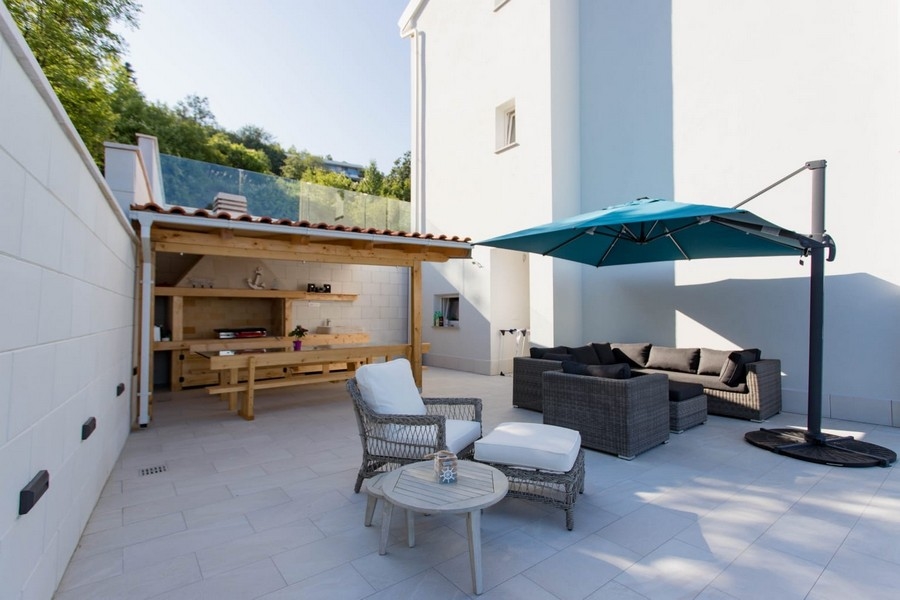 Terrazza coperta con area lounge e ombrellone