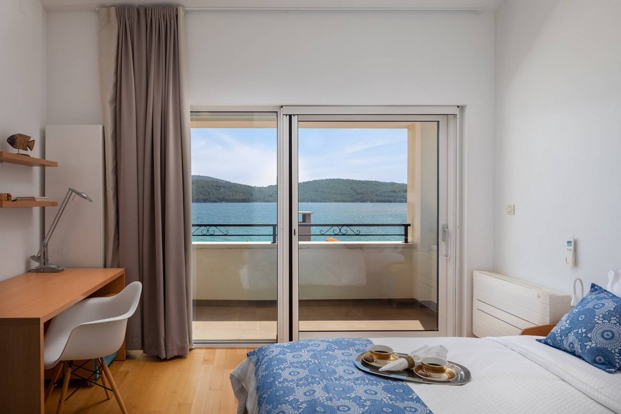 Camera da letto con scrivania e porta del balcone sulla baia