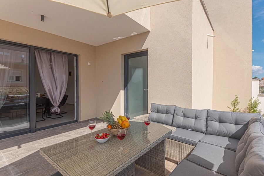 Terrazza con lounge in rattan e tavolo apparecchiato