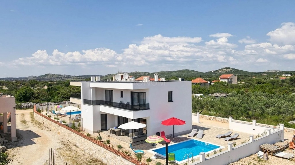 Veduta aerea della casa bifamiliare con piscina e lettini
