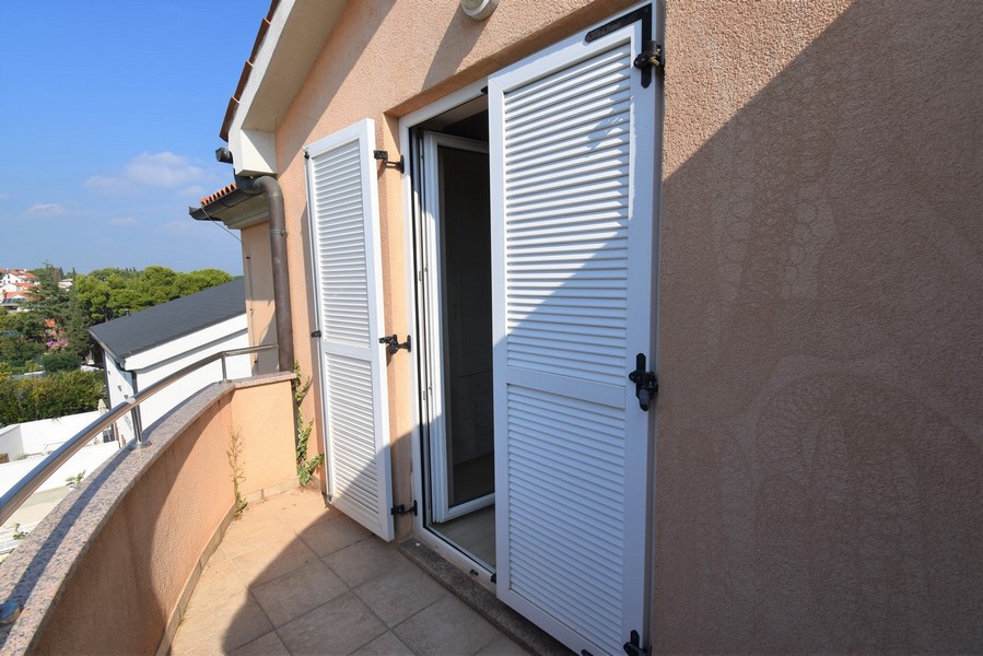 Balcone con persiane bianche a lamelle alla porta della terrazza