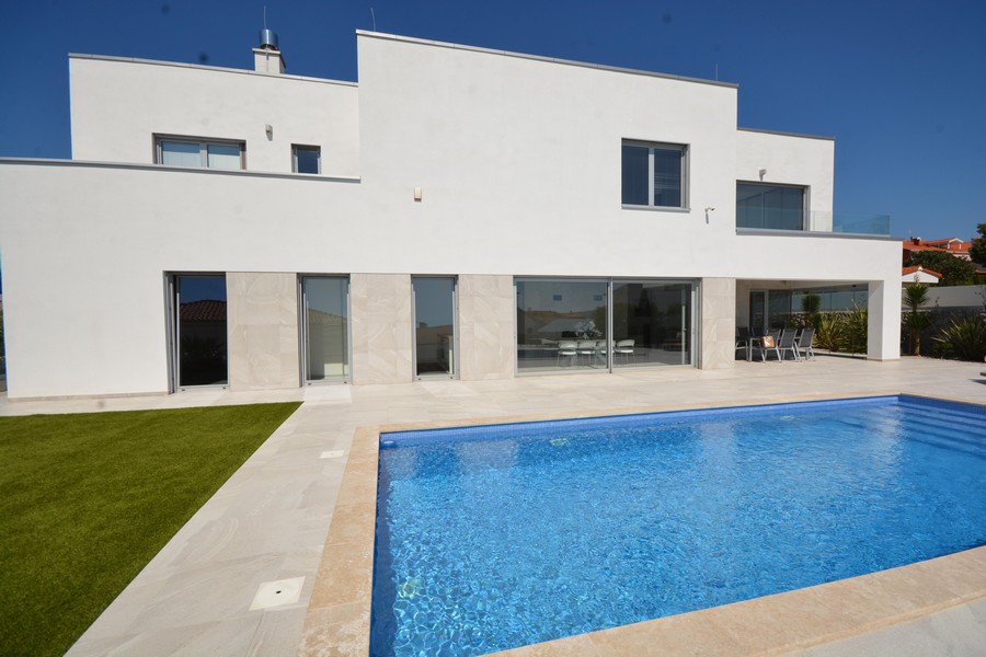 Villa bianca con piscina e prato alla luce del sole