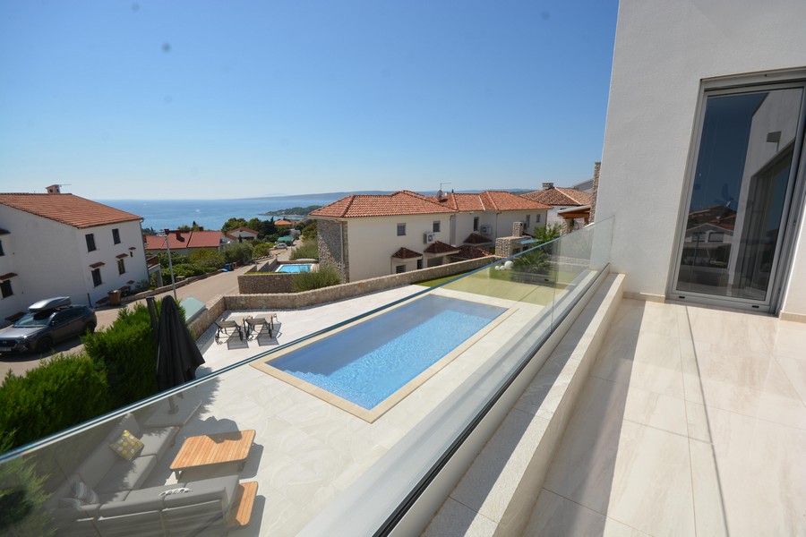 Vista dal balcone sulla piscina, sui tetti e sul mare