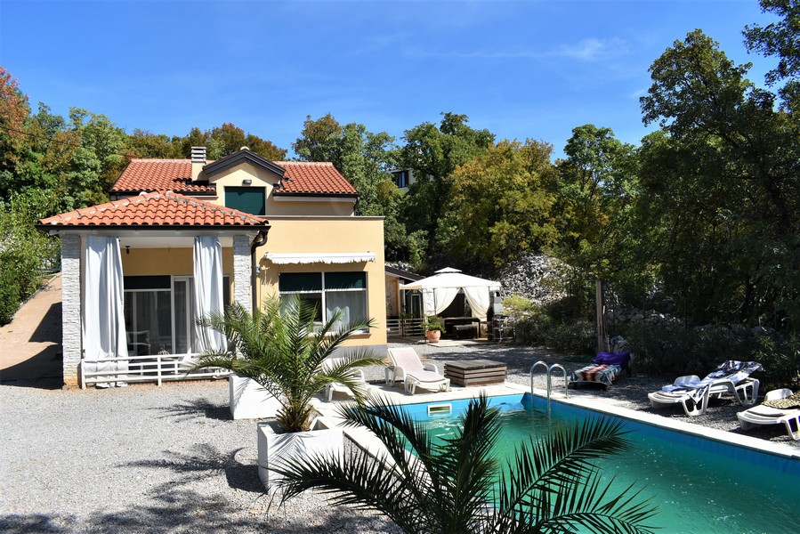 Casa a Kostrena con piscina e palma nel giardino di ghiaia
