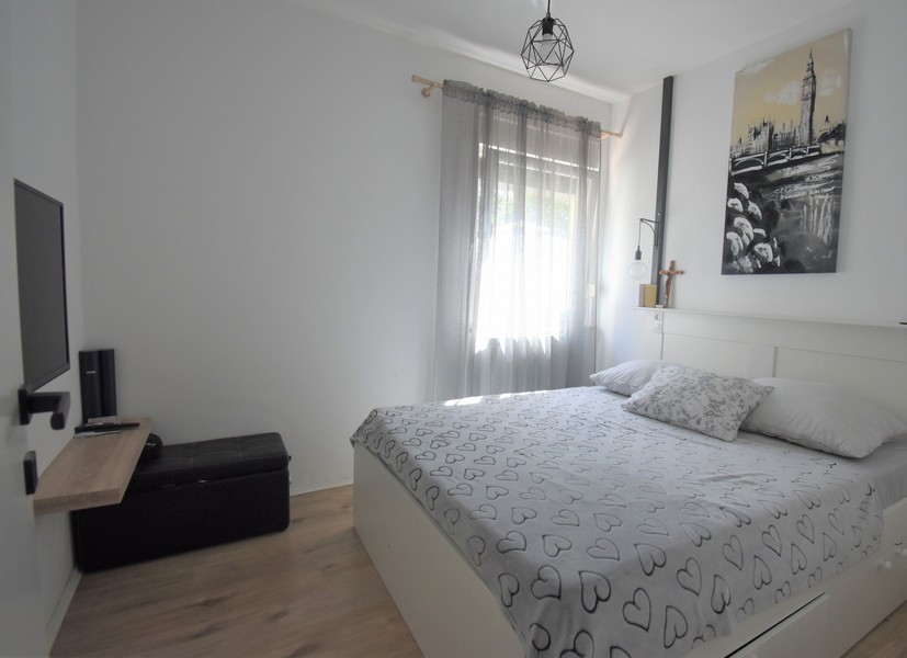 Camera da letto con televisore e quadro sopra il letto