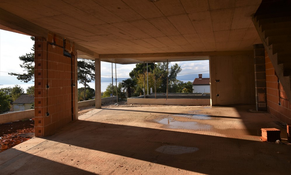 Ambiente al grezzo aperto con vista sull'acqua attraverso l'apertura