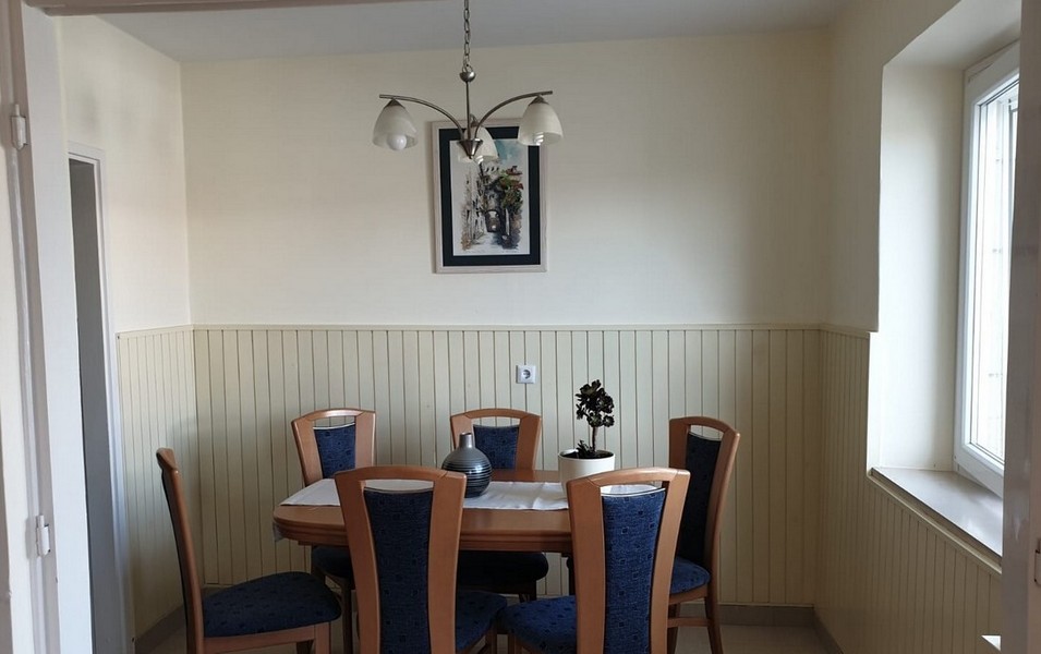Sala da pranzo con tavolo in legno e sedie imbottite blu