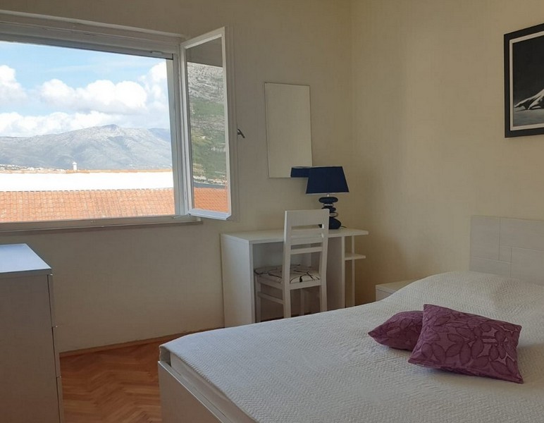 Camera da letto con finestra aperta verso i monti
